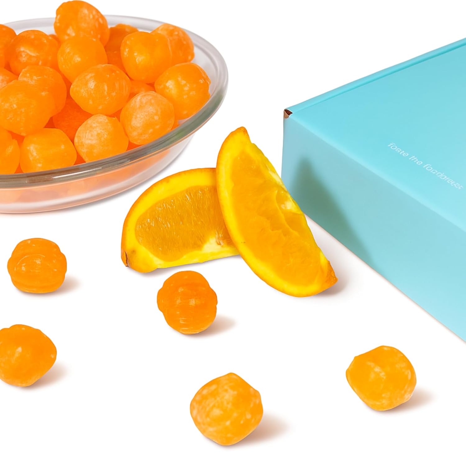 Andy Anand sugar-free sour orange hard candy in a bowl, garnished with orange pieces, European specialty, keto-friendly.