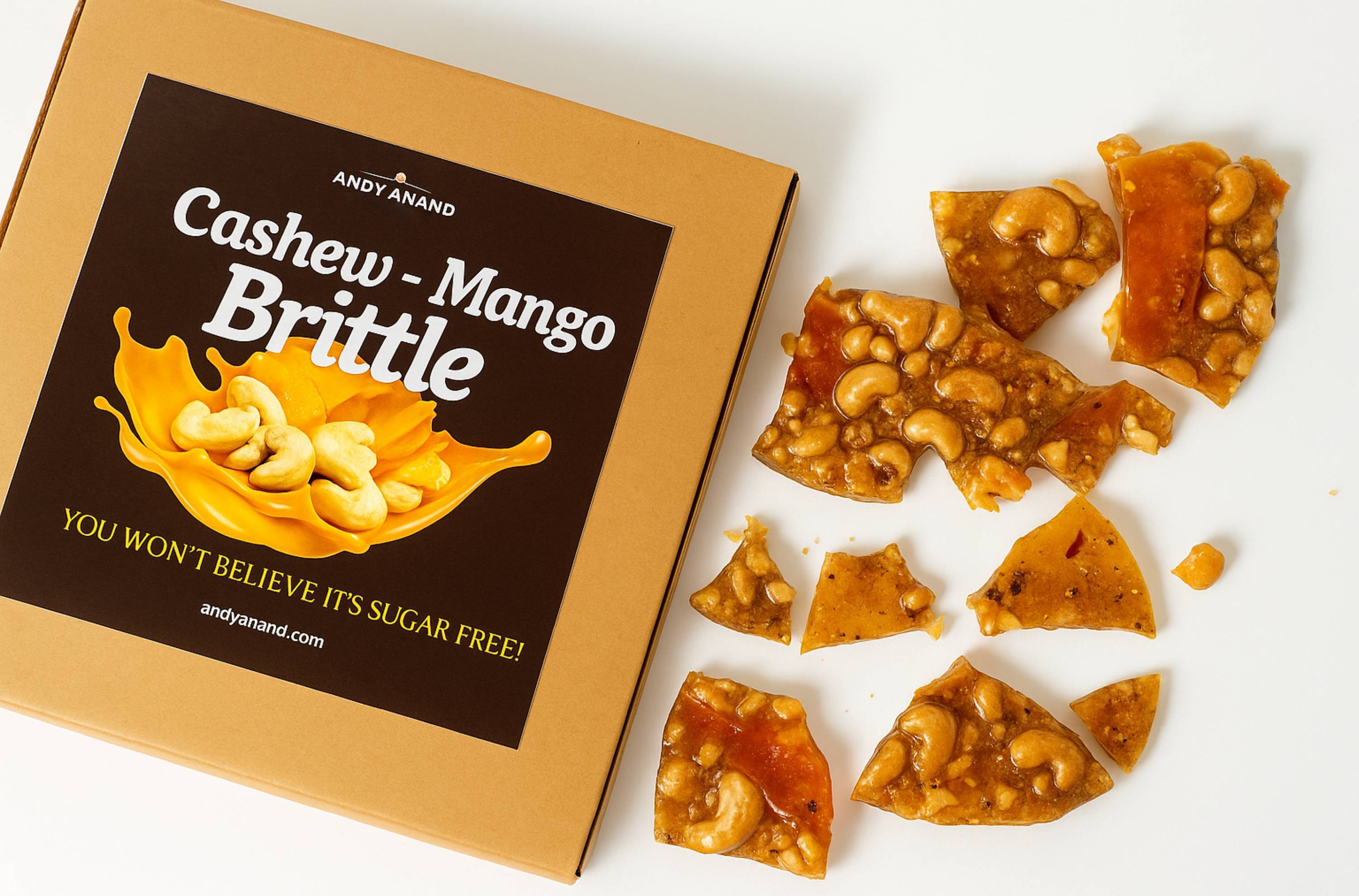 Andy Anand sugar-free mango & cashew brittle 1 lb, Italian croccante in gift box, pieces arranged aesthetically.