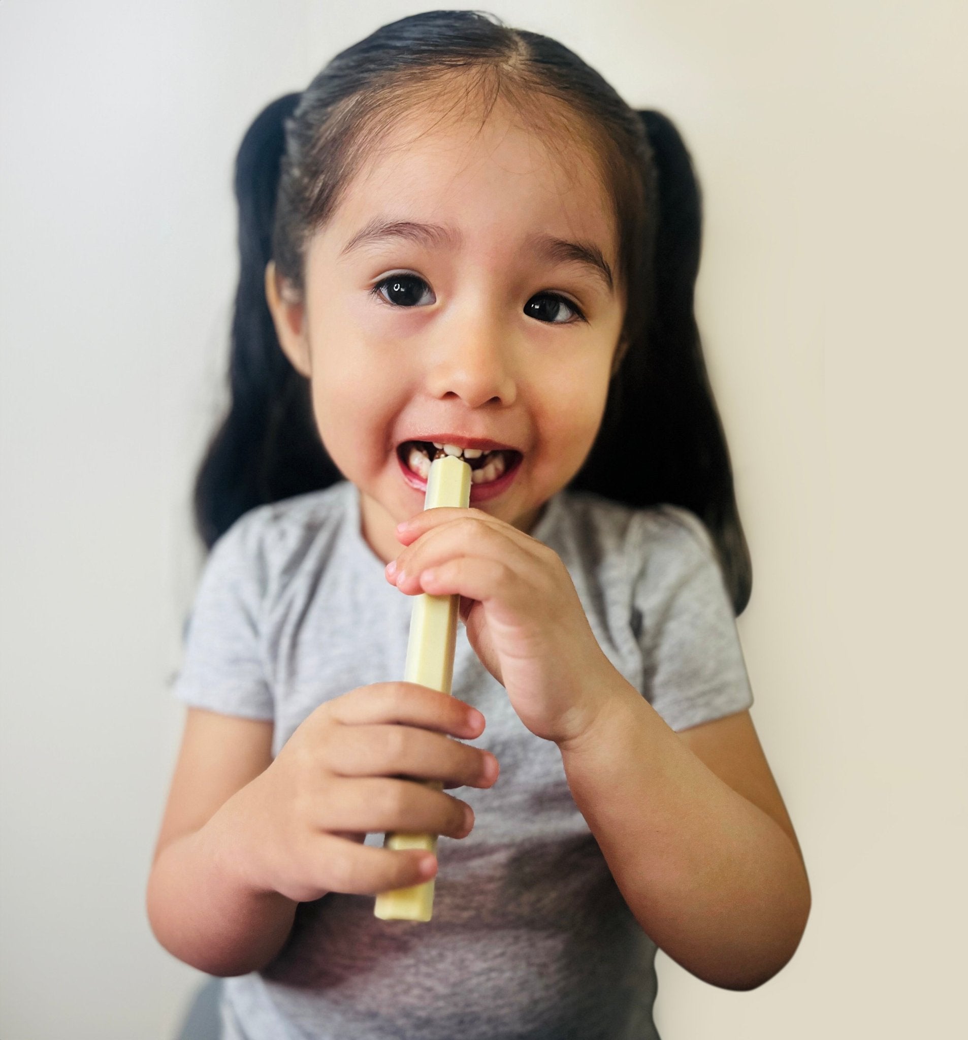 Milk Chocolate Delightful young child enjoying a milk chocolate crayon treat, an appealing and playful product from the Andy Anand Chocolates brand. Andy Anand Chocolates, All Products, Products, Milk Chocolate.