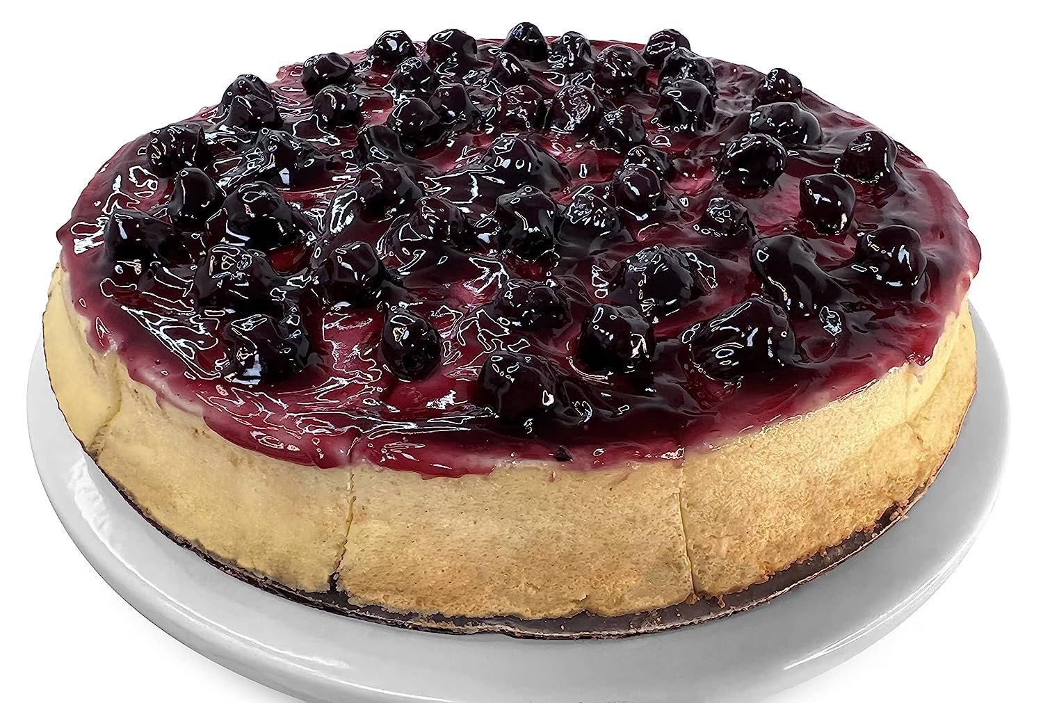 Blueberry cheesecake topped with fresh blueberry glaze on a white plate