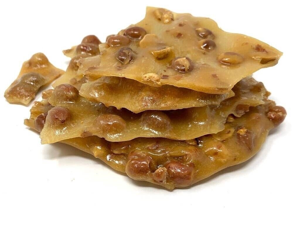 Handmade sugar free peanut brittle pieces stacked, showcasing crunchy texture and peanuts, a guilt-free snack option.