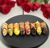 Assorted gluten-free Italian cannoli with various toppings on a black plate, featuring flavors such as tiramisu cream, coffee, orange, red berries cream, chocolate, pistachio, caramel, and lemon taste, handcrafted by La Pasticceria and available exclusively through Andy Anand Chocolates, All Products, Products, New Arrivals, Italian Delicacies imported from Italy.