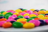 Colorful assortment of sugar-free Jordan almonds coated in a thin layer of pastel-colored candy. Vibrant hues of pink, yellow, green, and blue create an appetizing and visually appealing display. Andy Anand Chocolates, All Products, Products