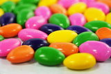 Assorted colorful sugar-free Jordan almonds with a chocolate coating, showcasing a variety of vibrant pastel shades including pink, blue, white, and yellow. Andy Anand Chocolates, All Products, Products.