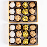 A delectable assortment of Andy Anand's Exquisite Gourmet Date Truffles, showcasing a medley of nuts, pistachios, and hazelnuts in a no-sugar-added confection. Andy Anand Chocolates, All Products,Products